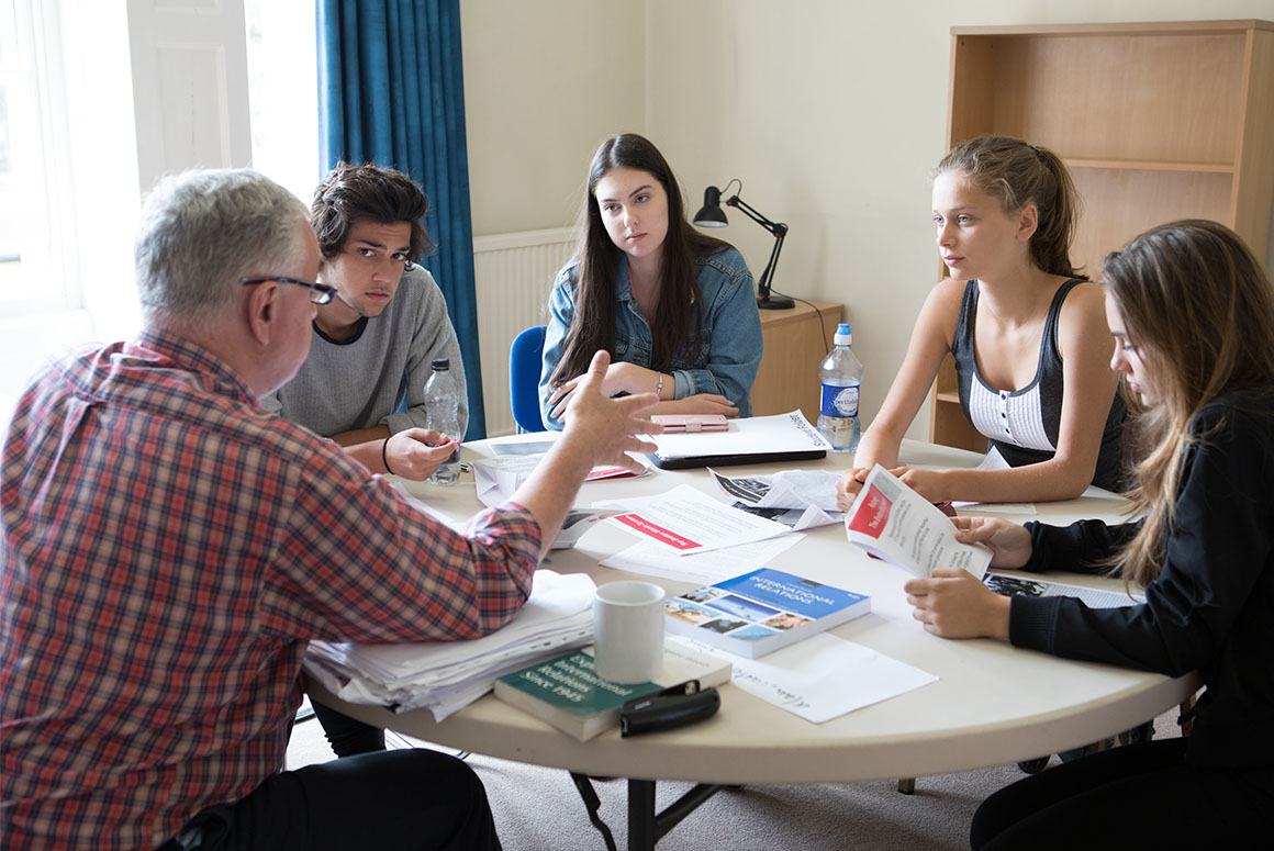 Students and tutor sitting around a table