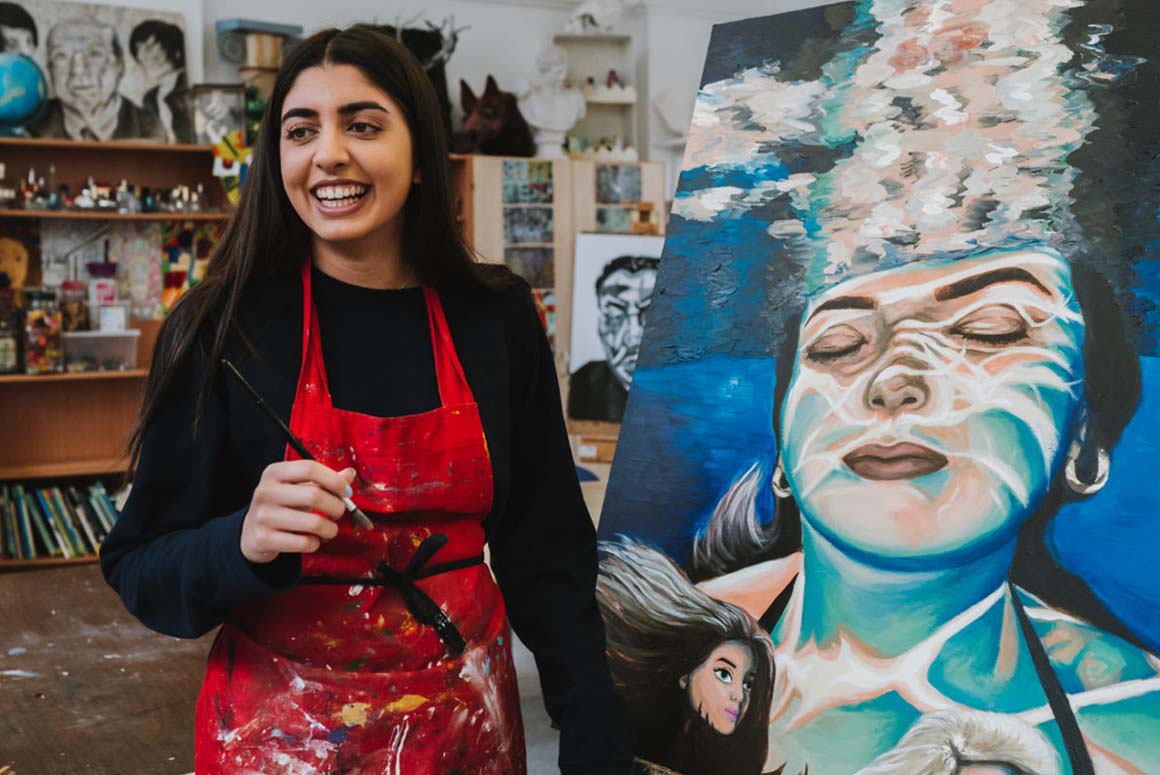 Stamford High School student in front of painting