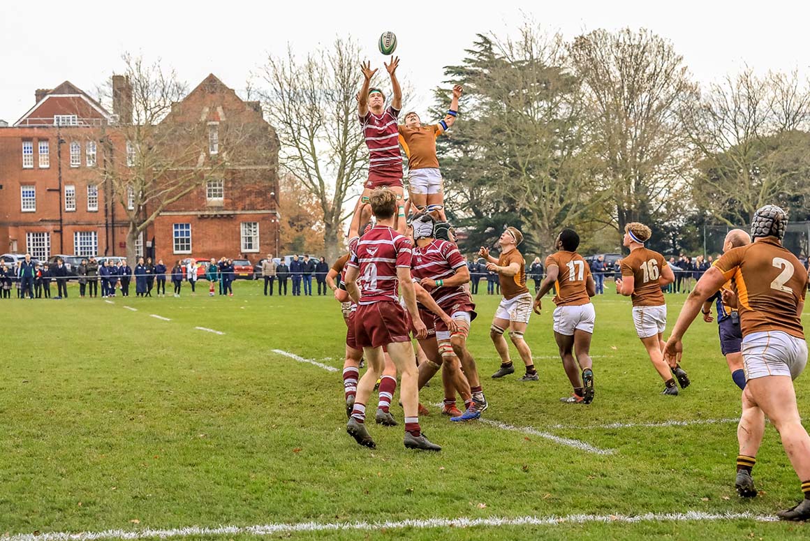 Male Haileybury School students catching rugby ball