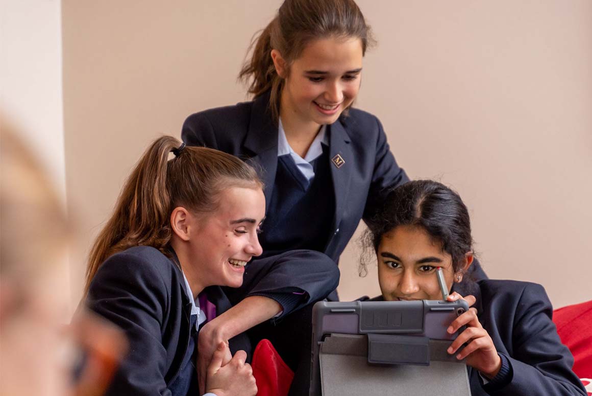 Female Haileybury School students working on tablet