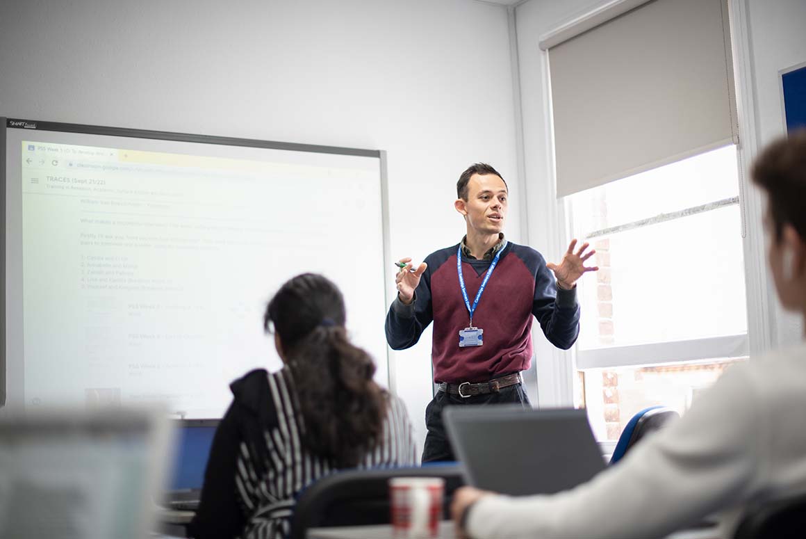Cambridge Seminars College tutor using whiteboard in classroom