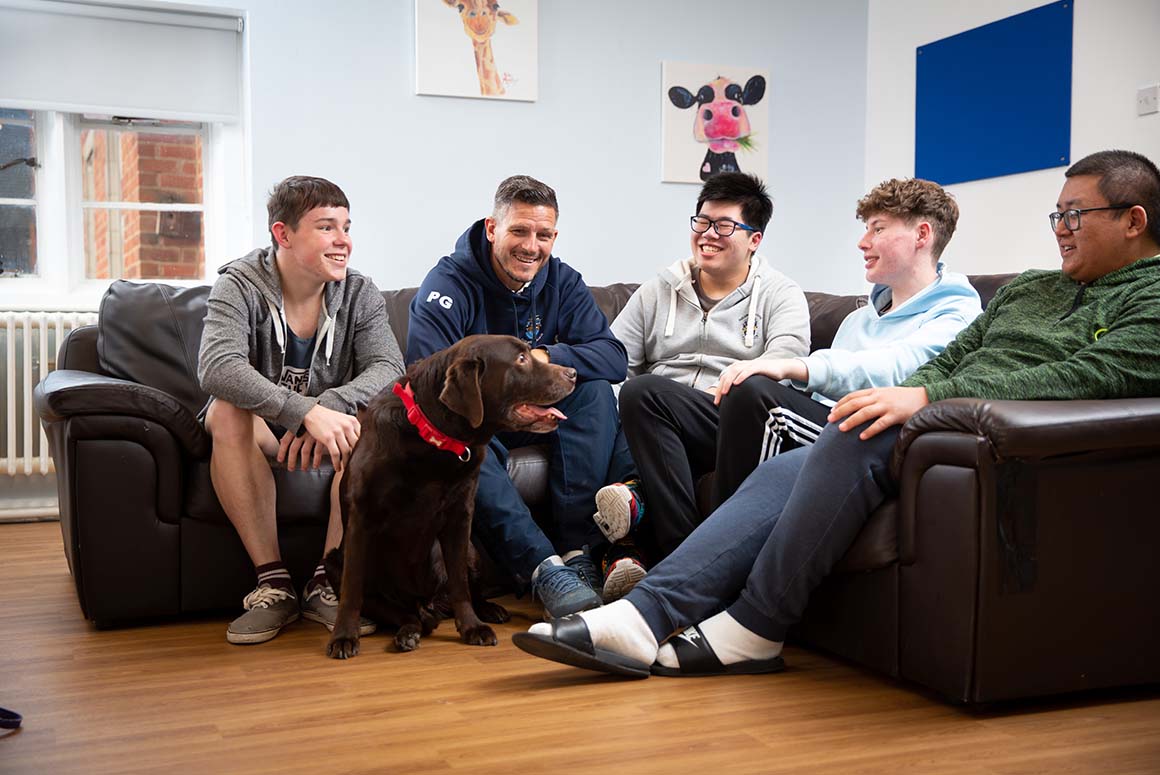 Ratcliffe College boarding students sitting with dog