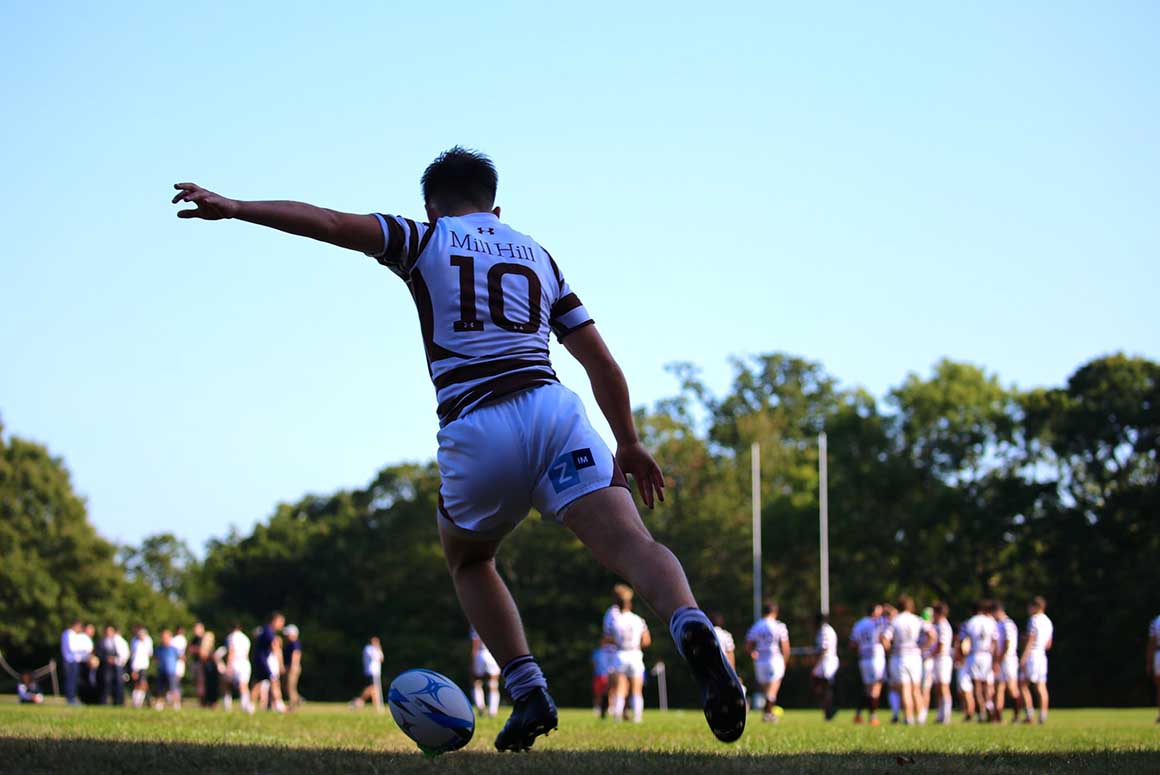 Mill Hill School student kicking rugby ball