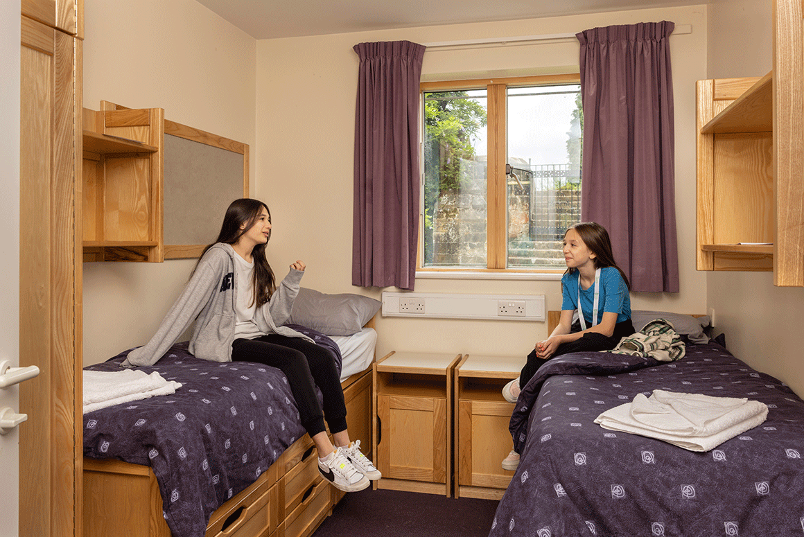 Two female British Summer School students talking in their shared bedroom