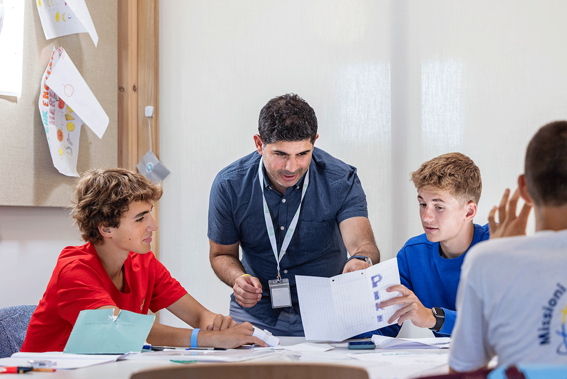 British Summer School tutor helping two students